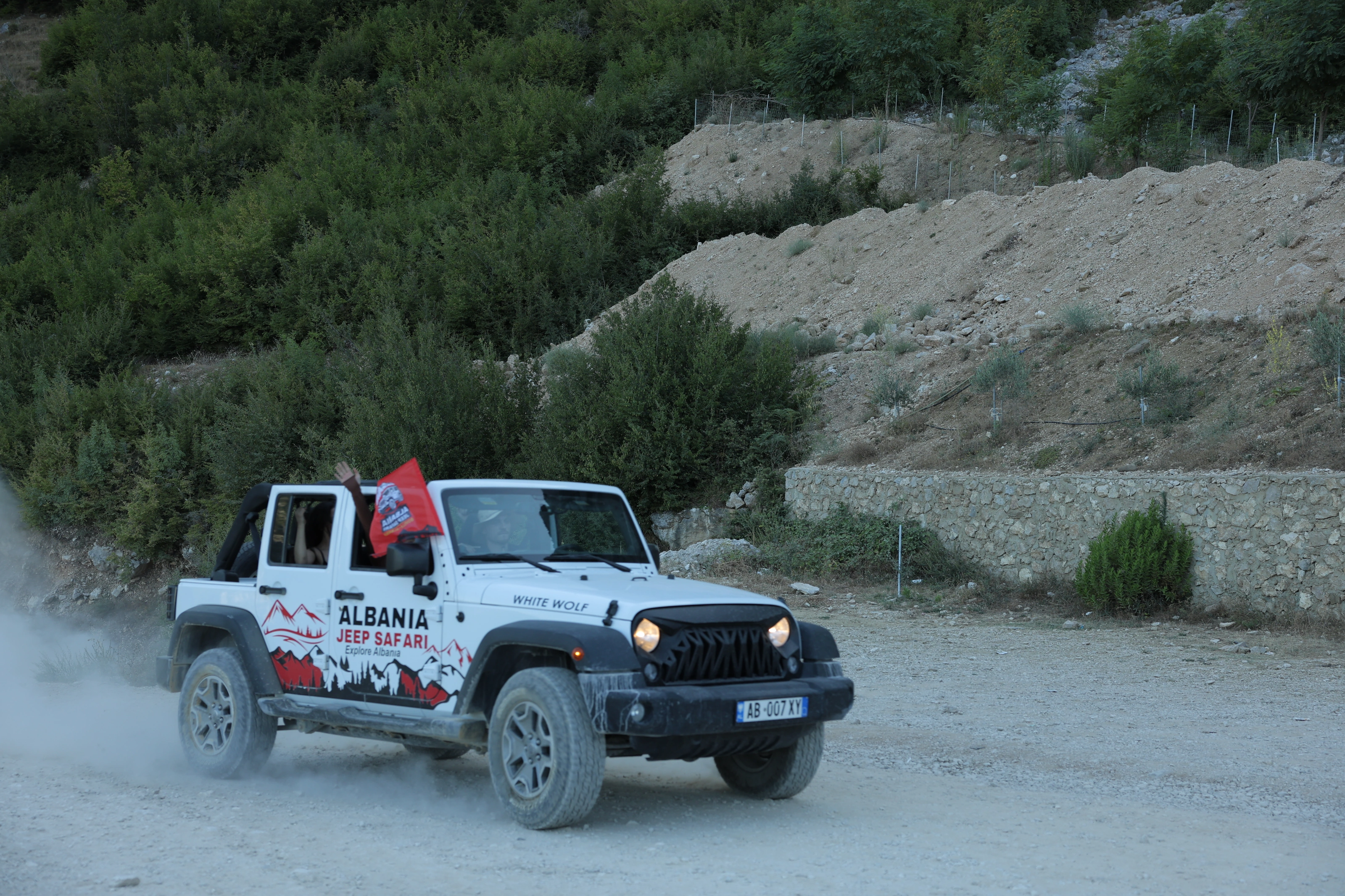 White Wrangler on the white gravel road below the limestone cliffs