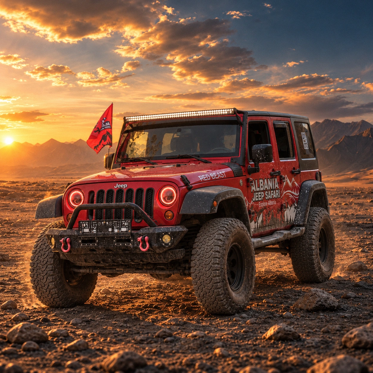 Red Beast, a red Jeep Wrangler in Albania Jeep Safari livery, on a rocky plain at sunset